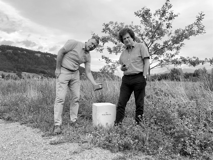 Vorsteher Freddy Kaiser und Dr. Hanno Loewy vom Jüdischen Museum Hohenems begutachten am 7. Juli 2022 den Grenzstein beim Egelsee.